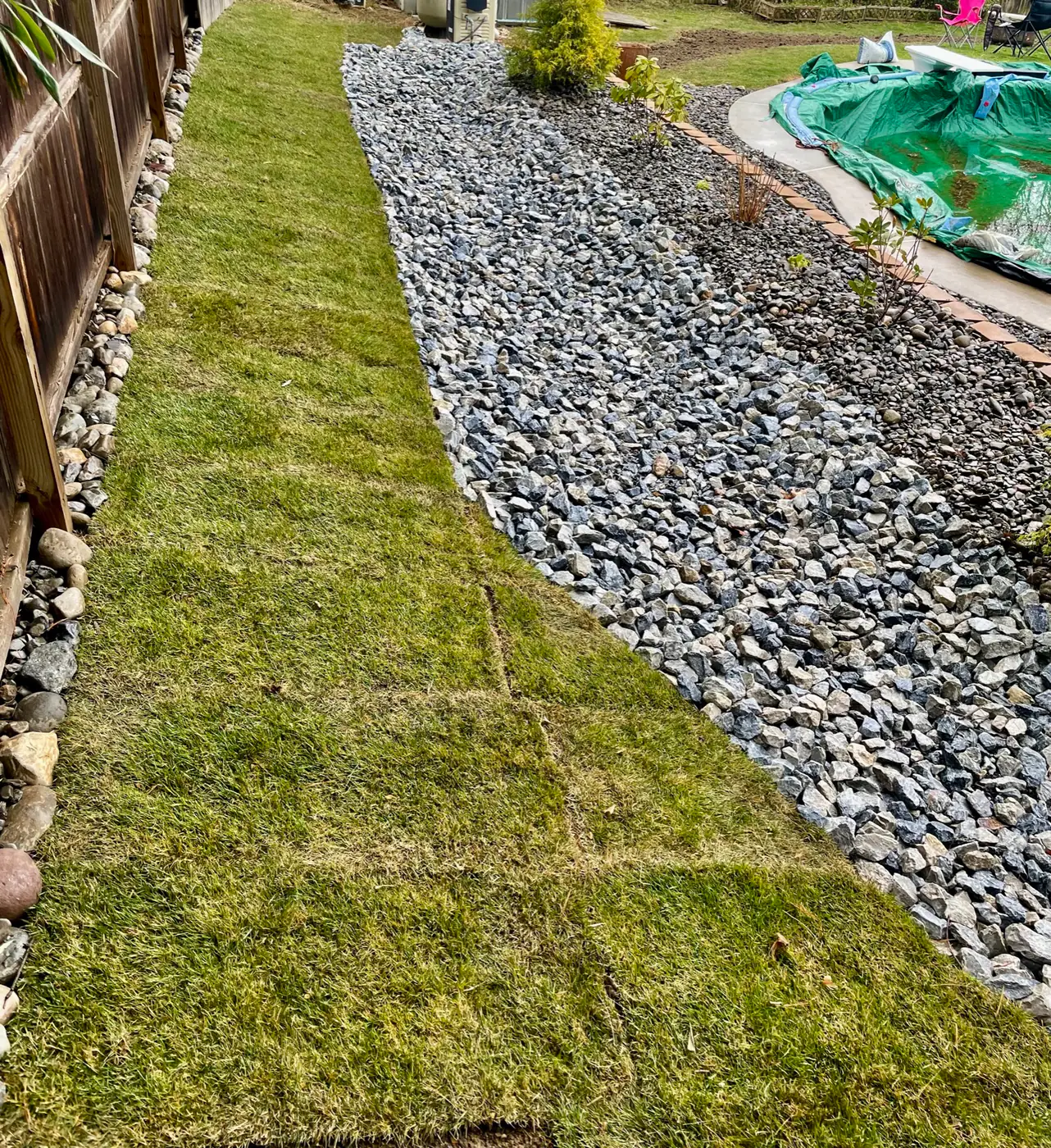 River-rock dry creek bed installed to carry storm water through a lawn