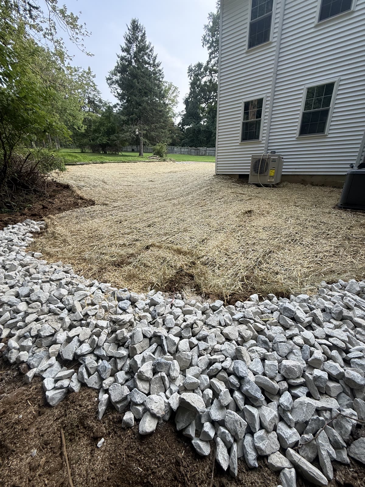 Close-up of the white stone French drain trench that carries water away from the foundation