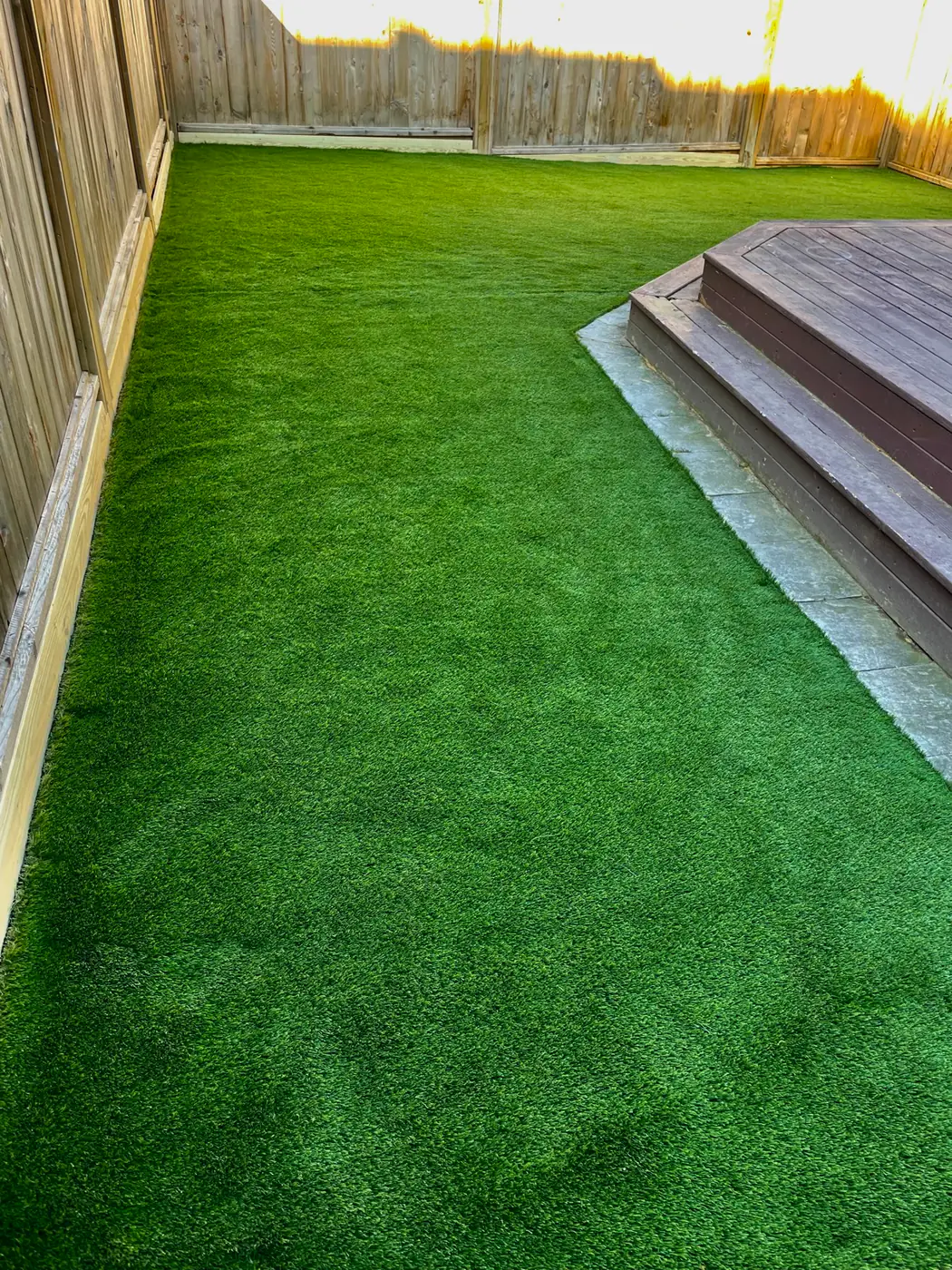 Worn-out patchy backyard lawn before artificial turf installation
